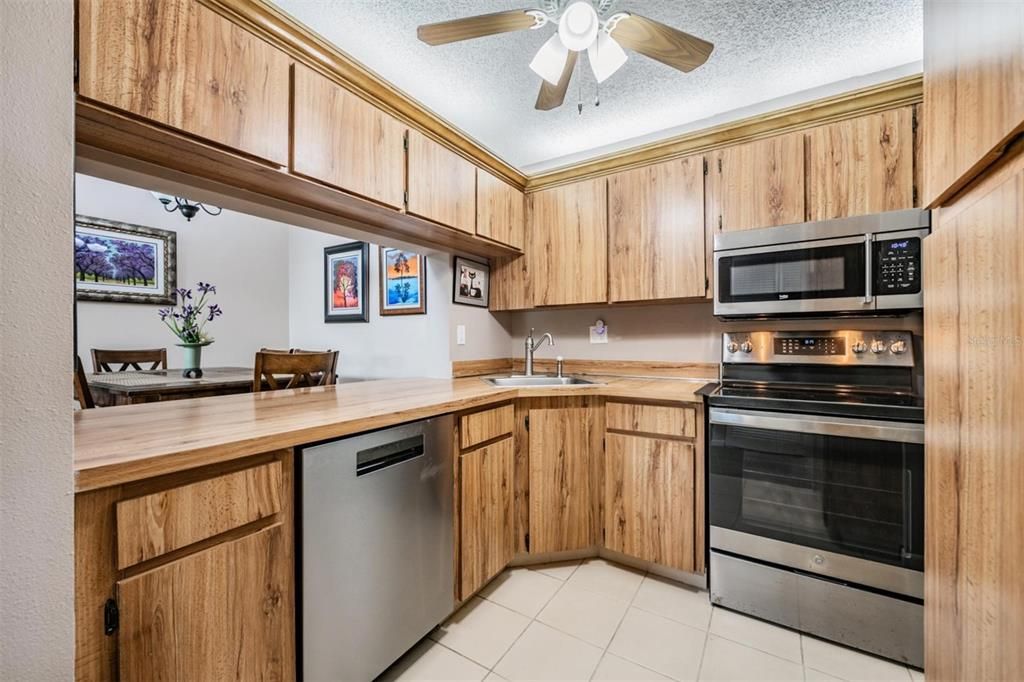 The kitchen is well-equipped with stainless steel appliances, a pantry, and plenty of cabinets and counterspace.