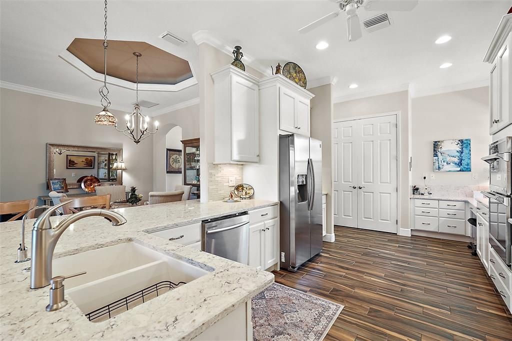 Quartz countertops, light colored cabinetry and unobtructed views of the dining and family rooms make this kitchen user friendly supporting convenient interaction with whatever is going on in the rest of the home.