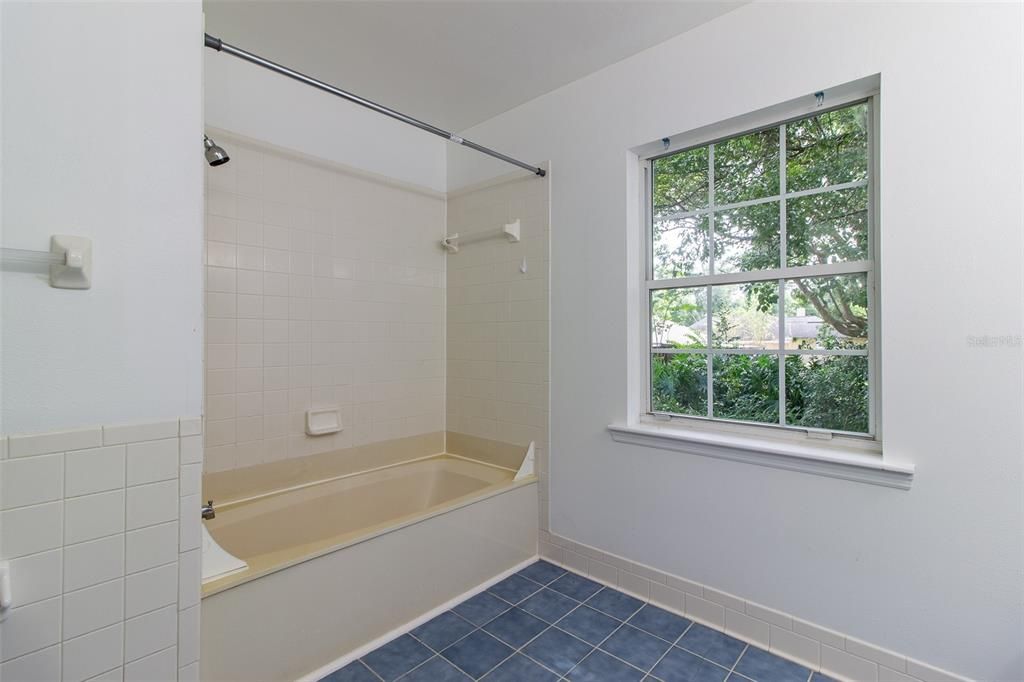 there is a tub and shower combo and tile floor.