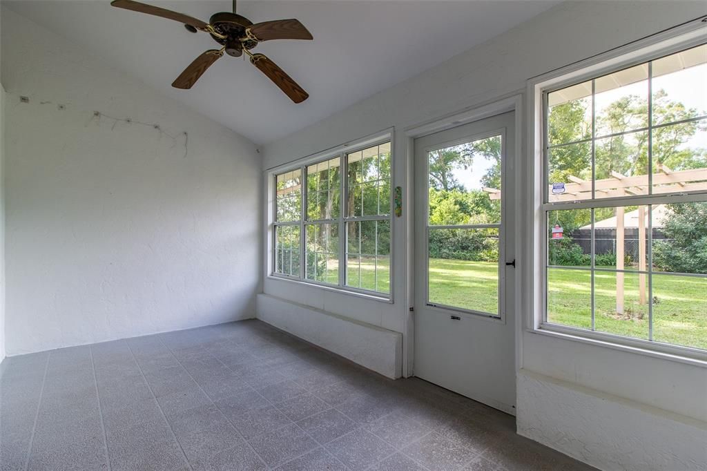 Lanai area has concrete floor with windows and door to large back yard.