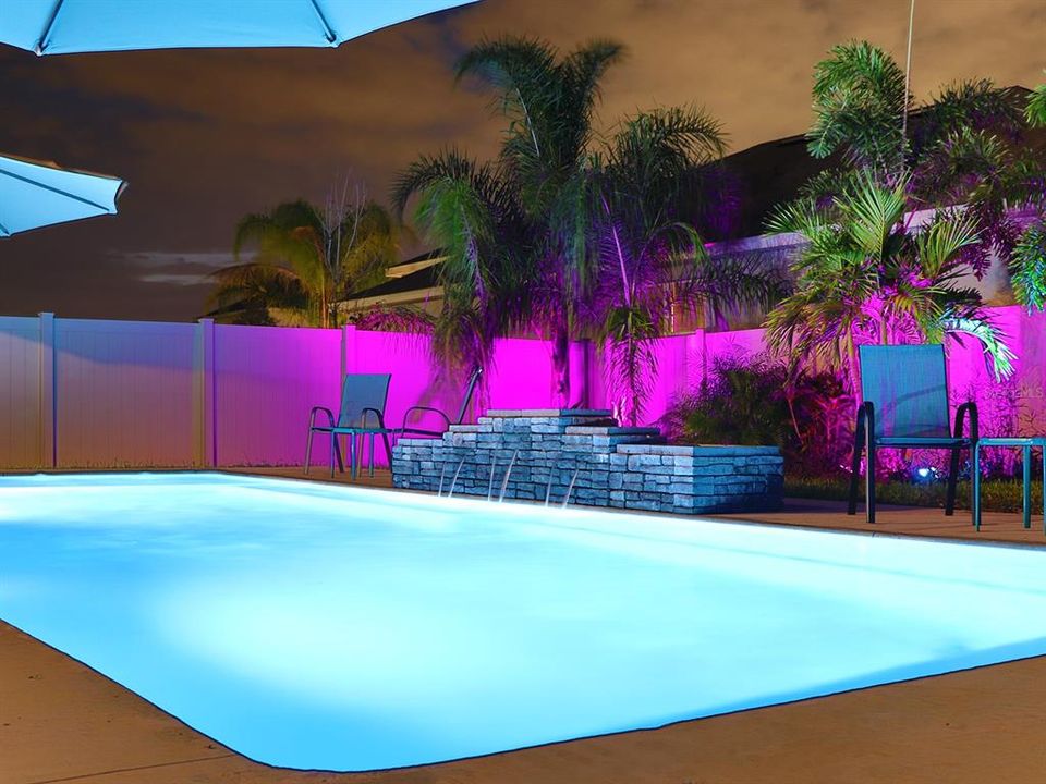 Nighttime backyard landscaping and heated pool