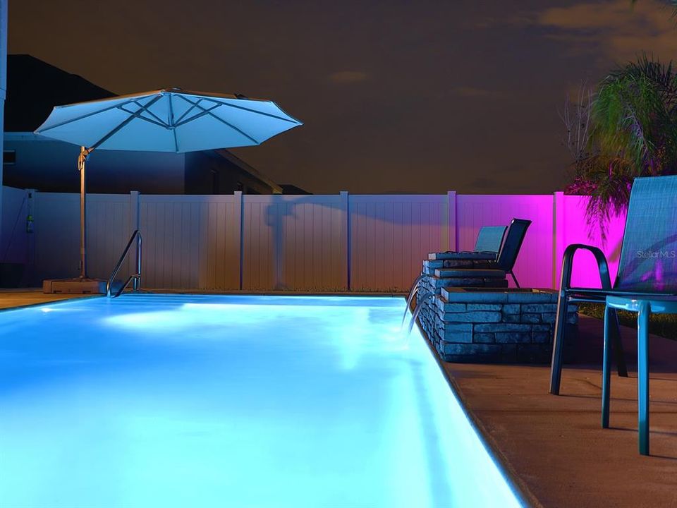 Waterfall and water features within heated pool, with lights