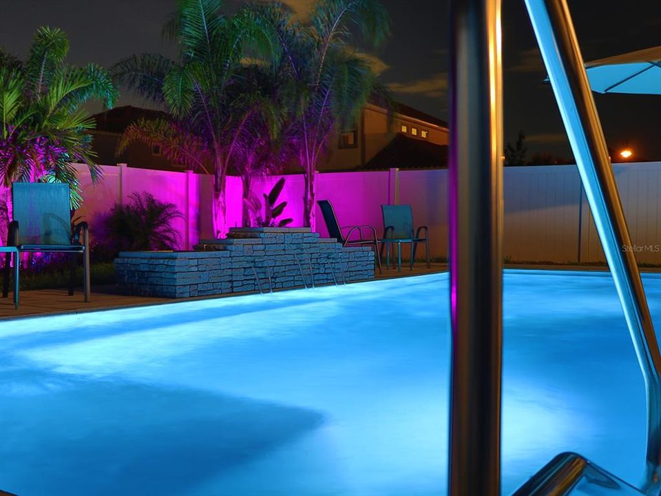 Waterfall and water features within heated pool, with lights