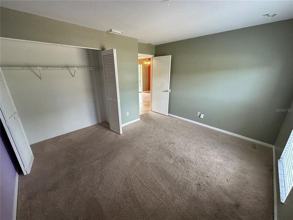 Bedroom #2 showing the long closet and the entry.