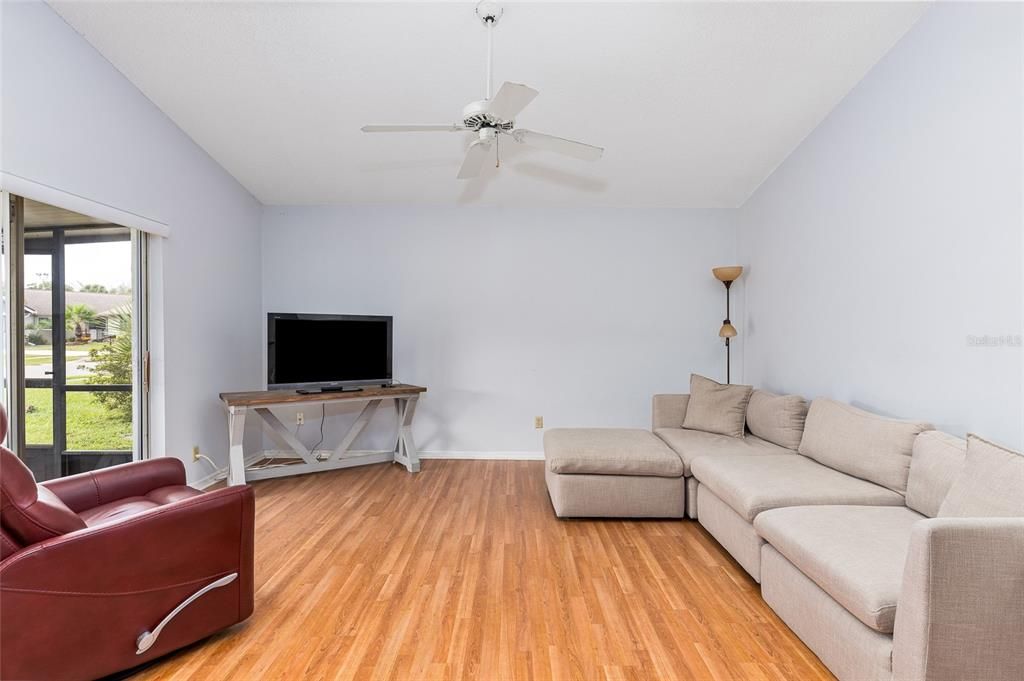 The living room has a lot of natural light from the sliding glass doors and the sky lights.