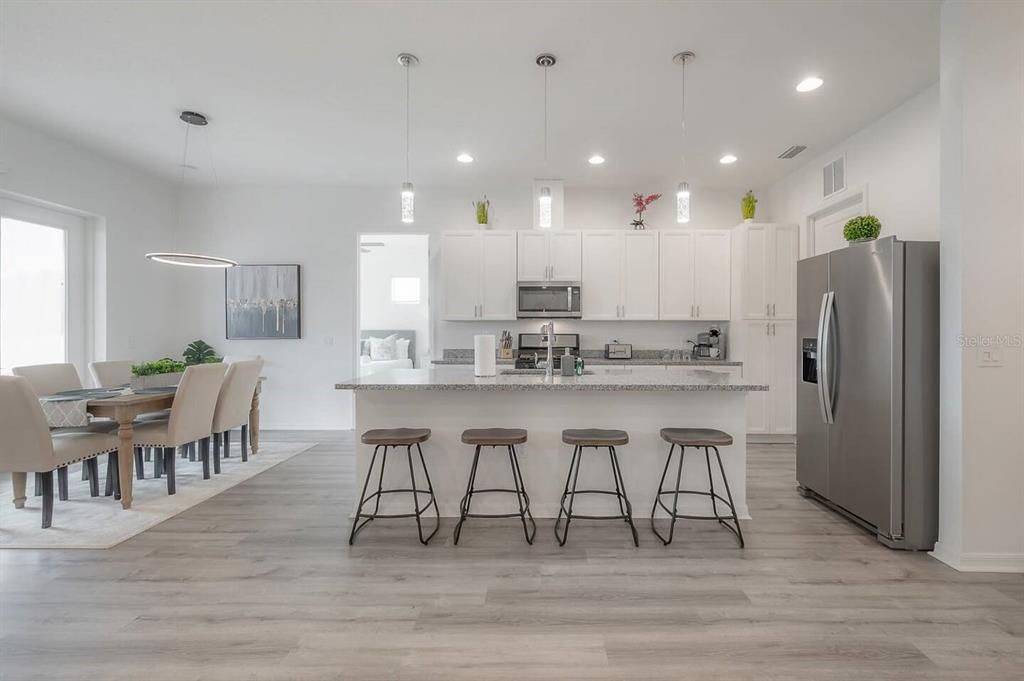 Kitchen & Dining area with Vaulted ceilings, gourmet kitchen with gas stove, open floorplan.