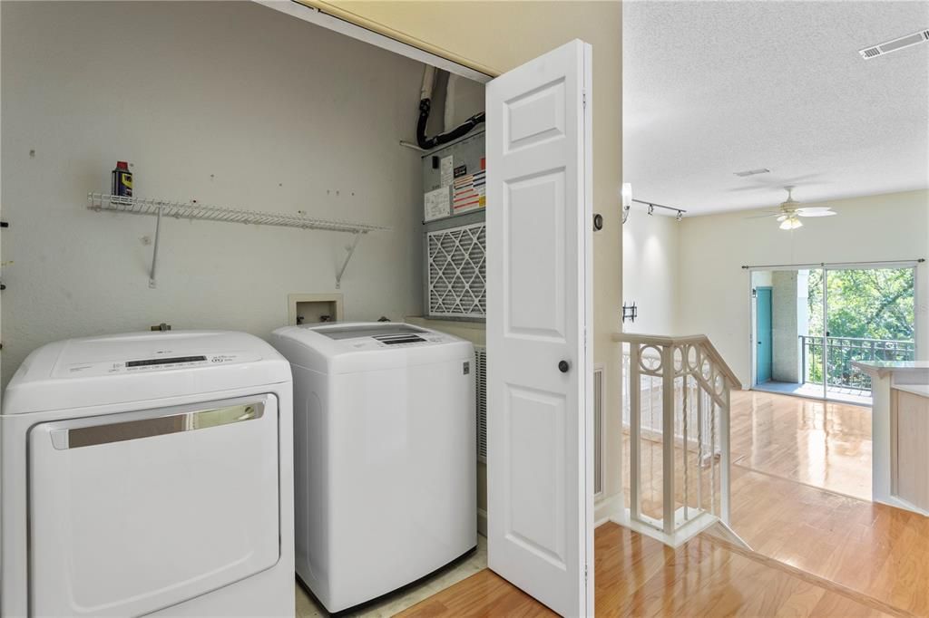 In unit laundry closet with full sized washer and dryer