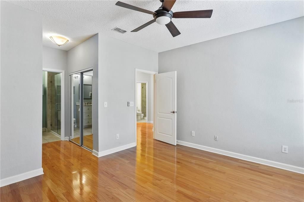 The primary bedroom with closet space on both sides of the walkway to the ensuite bathroom