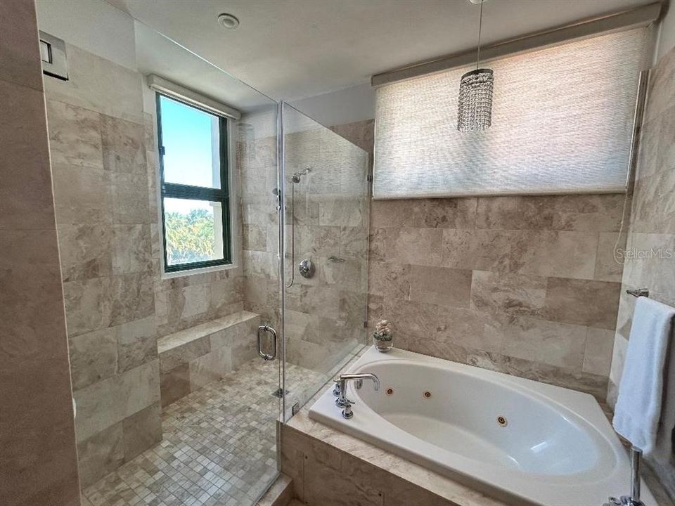 Jacuzzi tub and master shower. Marble walls and floors.