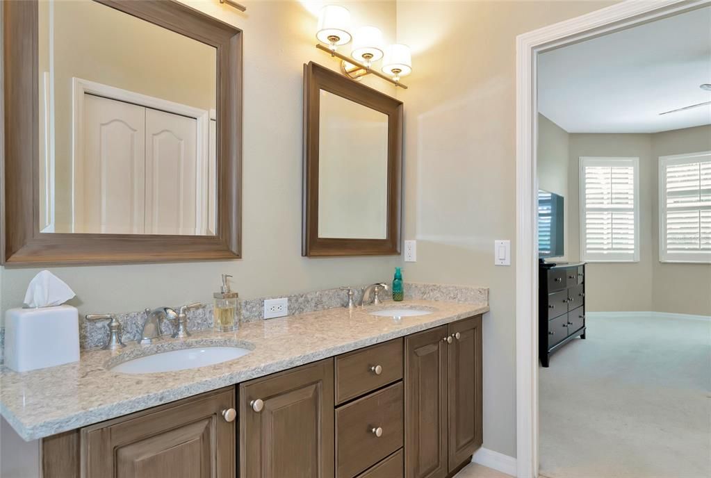 Primary suite bath w/ stone countertops.