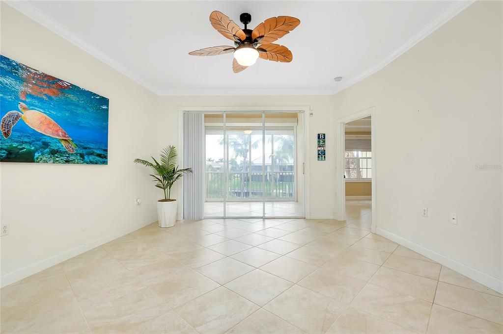 Living room with ceiling fan, light tile patterned flooring, and ornamental molding