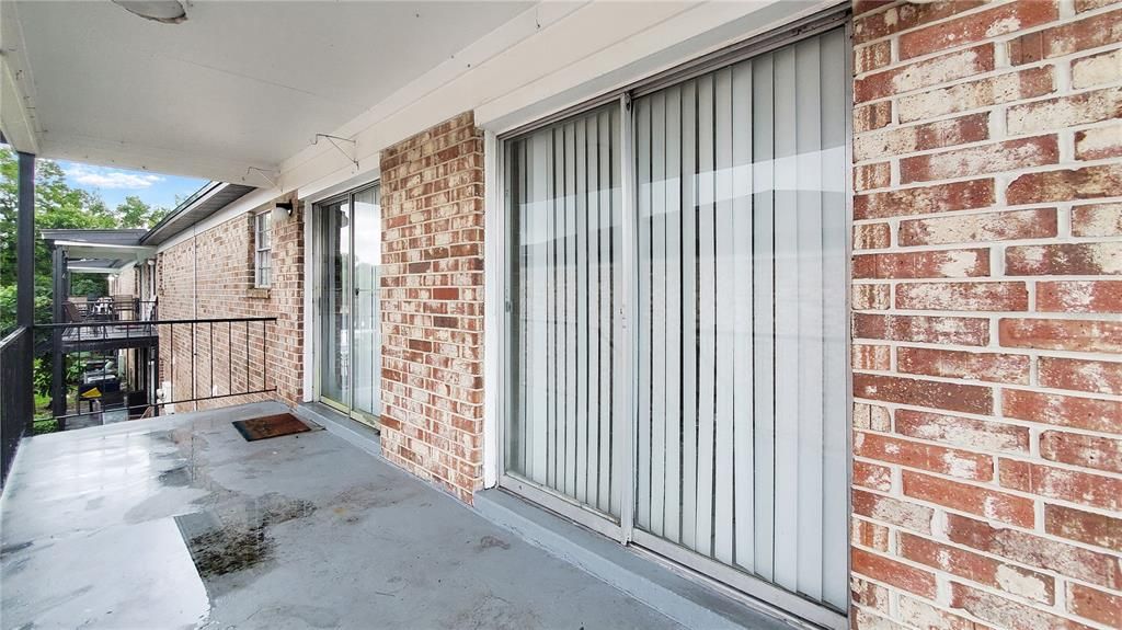 balcony with sliding doors leading to dining area and living