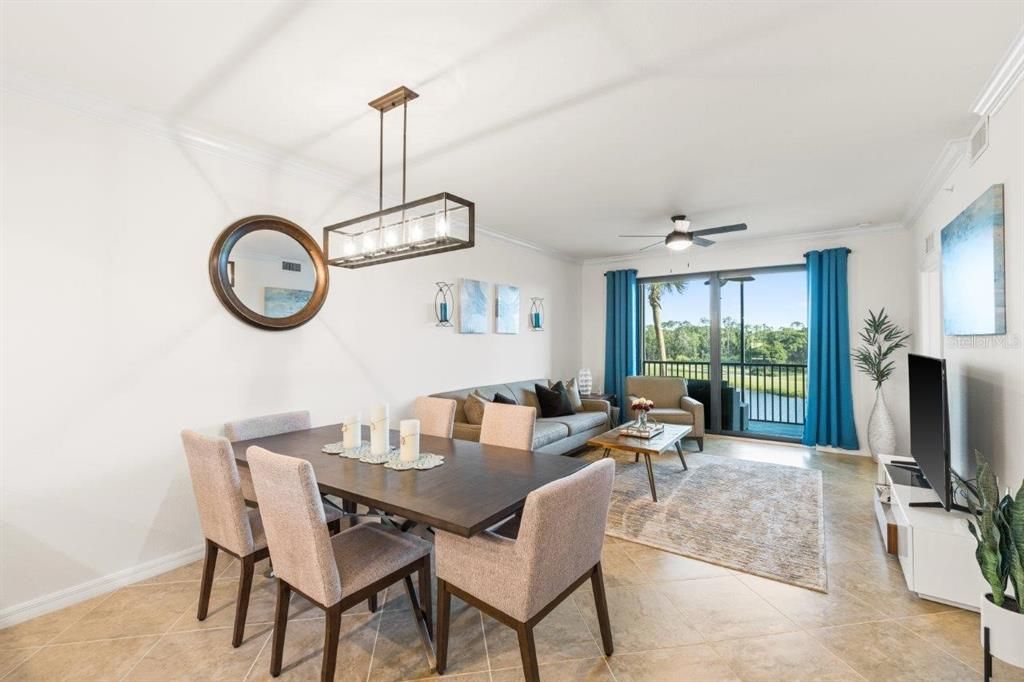 Spacious dining area featuring 16" tile, crown molding, and a stunning chandelier.