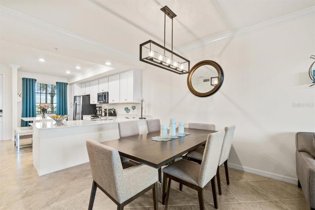 Spacious dining area featuring 16" tile, crown molding, and a stunning chandelier.