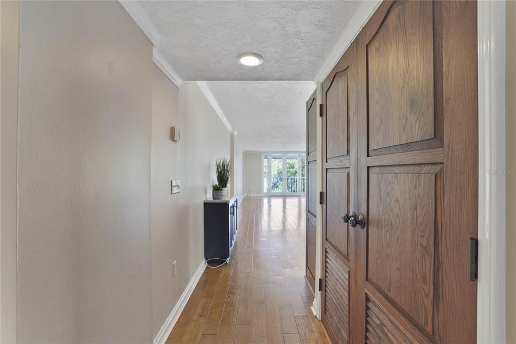 Hallway leading to living area with a/c, water heater closet