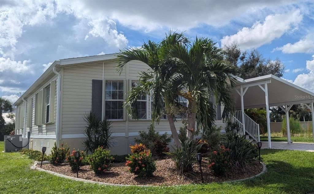 979 FRONT SIDE OF HOME SHOWING ALL WINDOWS WITH CUSTOM HURRICANE SHUTTERS AND BEAUTIFUL LANDSCAPING WITH CURBING