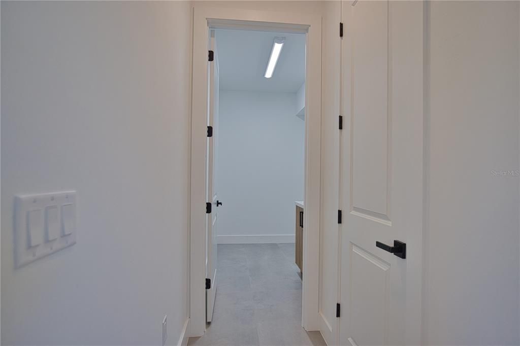 Hall to laundry room with garage door on right.