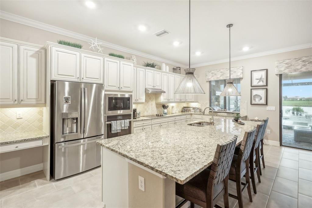 Kitchen with Built in Desktop, Stainless Steel GE Profile Appliances and Service Window for Outdoor Kitchen