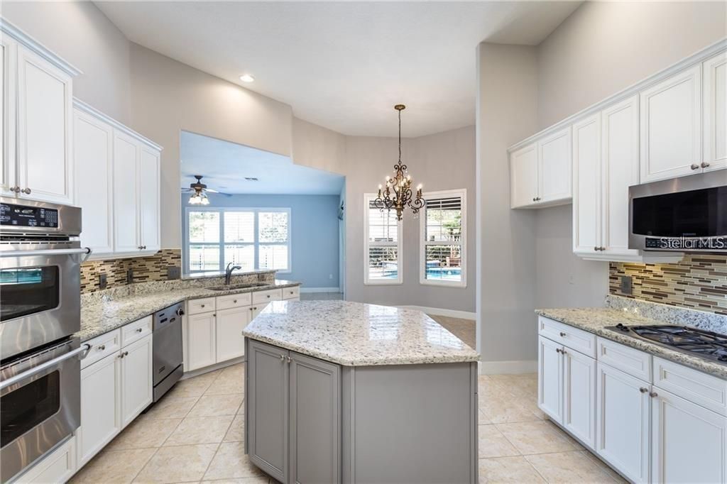 Kitchen looking toward pool, breakfast room, and family room