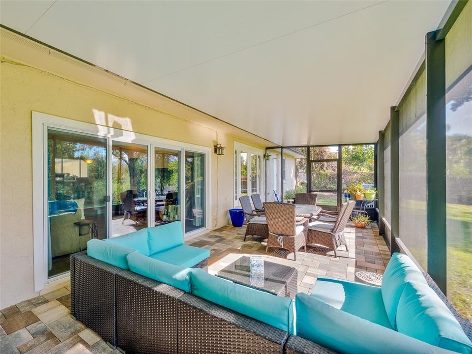 Spacious screened-in patio offering ample outdoor living space, perfect for entertaining or relaxing while enjoying the private backyard. Durable paver flooring and direct access to the home's interior through sliding glass doors enhance the indoor-outdoor flow.