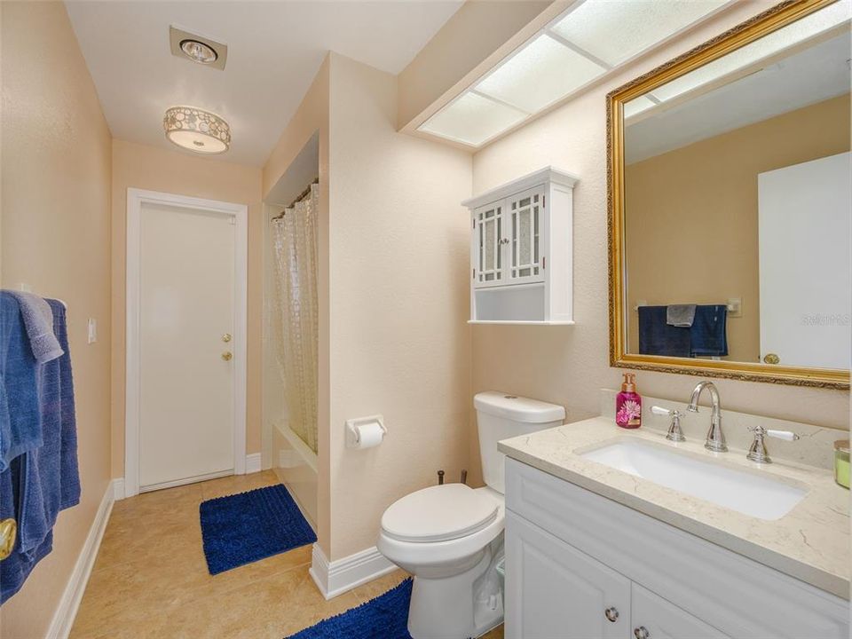 Bright and well-maintained bathroom featuring modern lighting, a sleek vanity with ample storage, and a shower-tub combination. The neutral color palette and quality fixtures provide a clean, updated feel. Perfect for guest or family use.