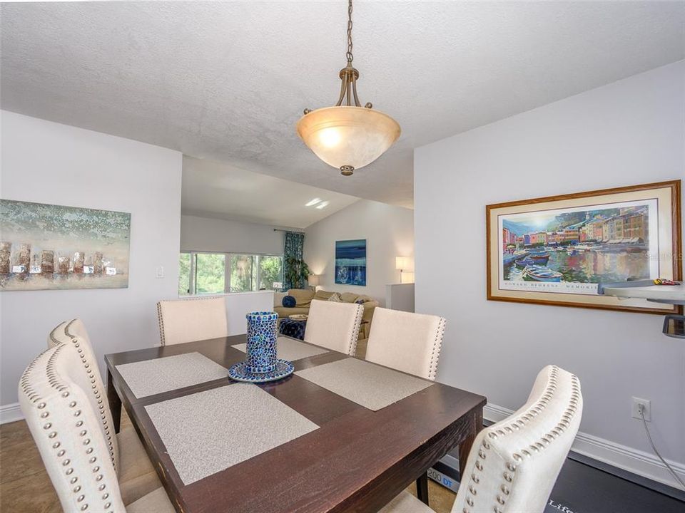 Spacious and bright dining area seamlessly opens into the living room, featuring large windows that bring in plenty of natural light. The open-concept layout is ideal for entertaining, offering a flow that enhances the home's inviting atmosphere.