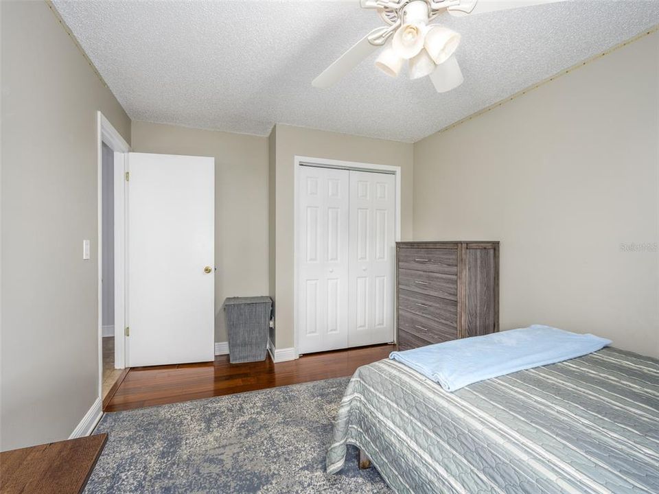 This bedroom offers ample natural light, neutral wall tones, and wood-look flooring. The closet space provides practical storage, and the room layout is versatile, ready to be personalized. Ideal as a guest room or secondary bedroom.