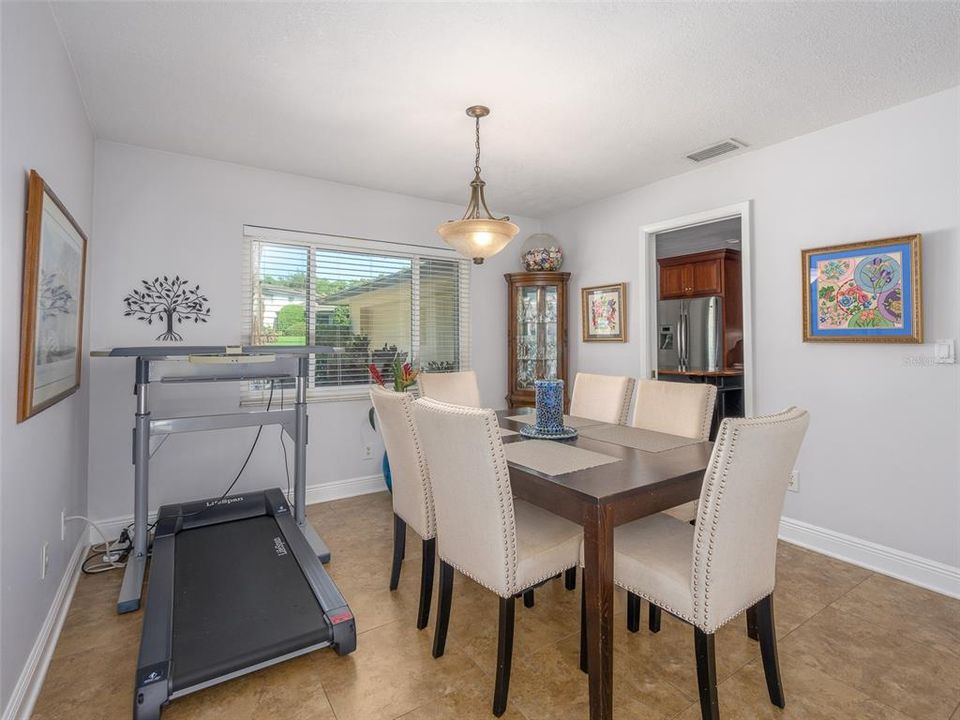 Bright dining area with large window letting in natural light. Neutral tones and tile flooring make this space adaptable to any style. Adjacent to the kitchen, it offers a convenient layout for entertaining and daily dining.