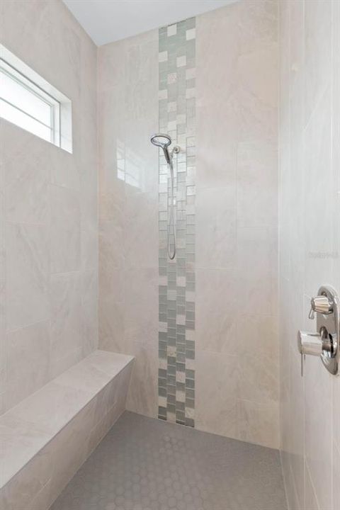 Walk in shower with transom window and bench.