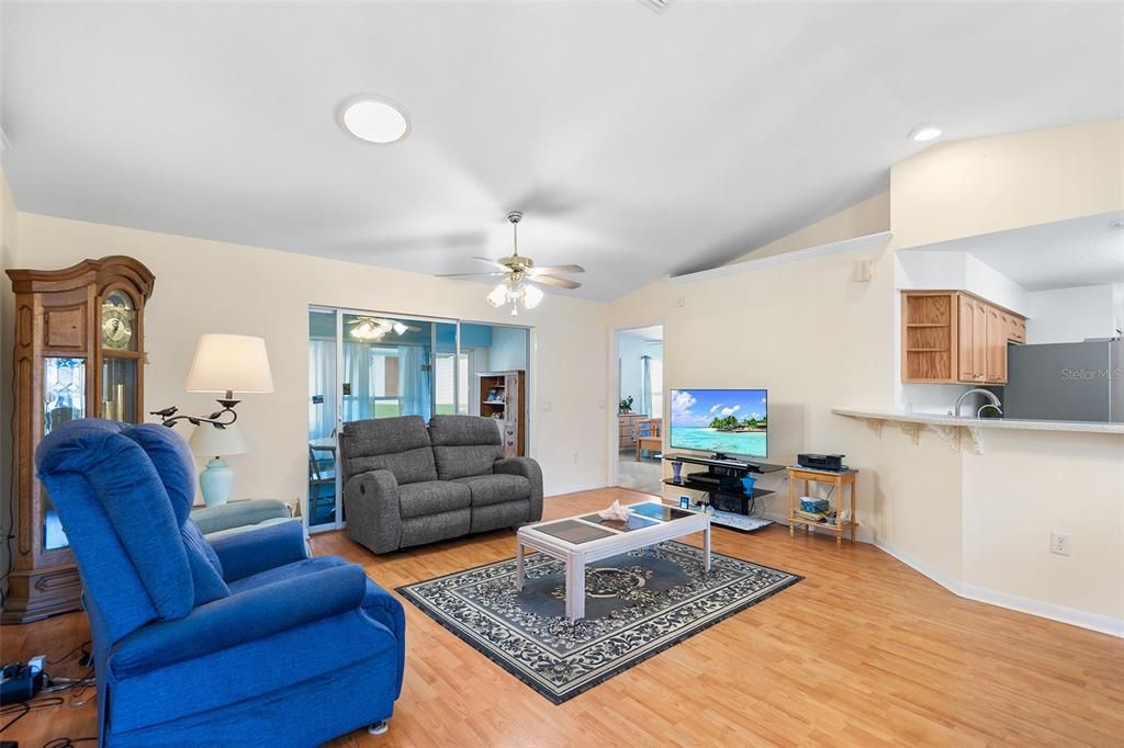 VIEW TOWARDS LIVING ROOM, BONUS ROOM & PRIMARY SUITE TO RIGHT. LAMINATE FLOORING. VAULTED CEILING WITH PLANT SHELVES!