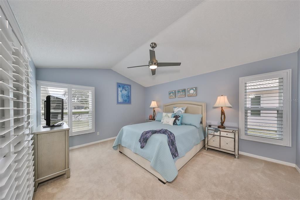 Primary bedroom has custom ceiling fan, and vaulted ceiling.