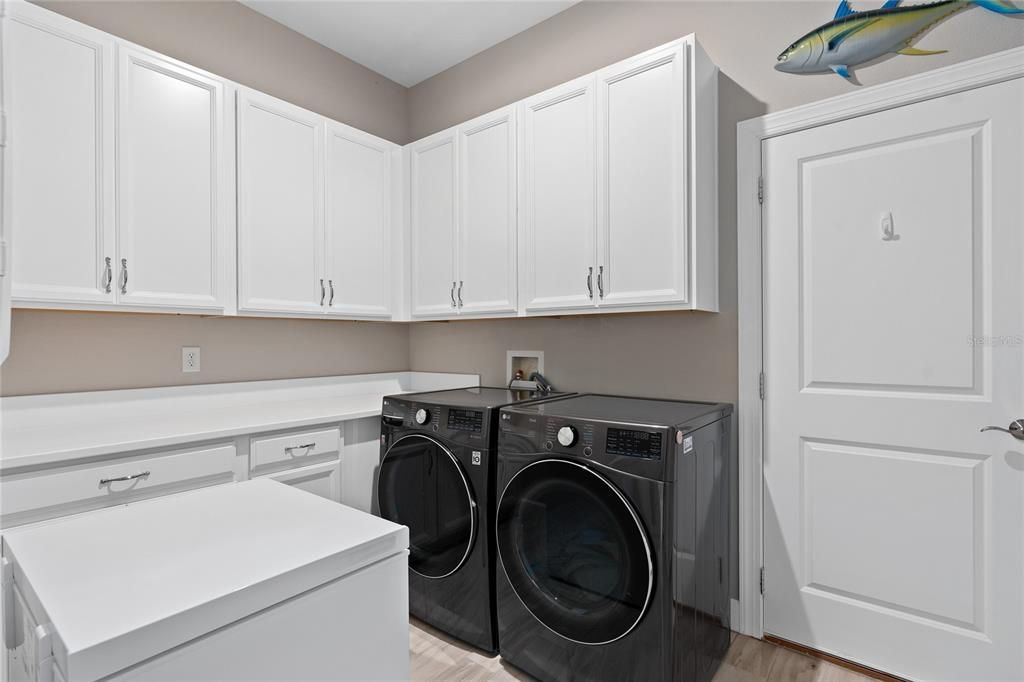 The Laundry Room features an array of Cabinetry for additional storage and a great countertop for folding clothes, etc..