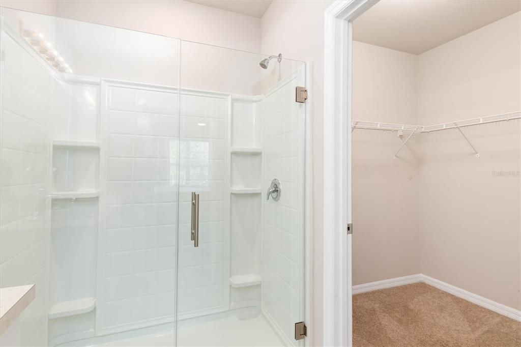 Primary bath, has large shower, walk in closet, and water closet