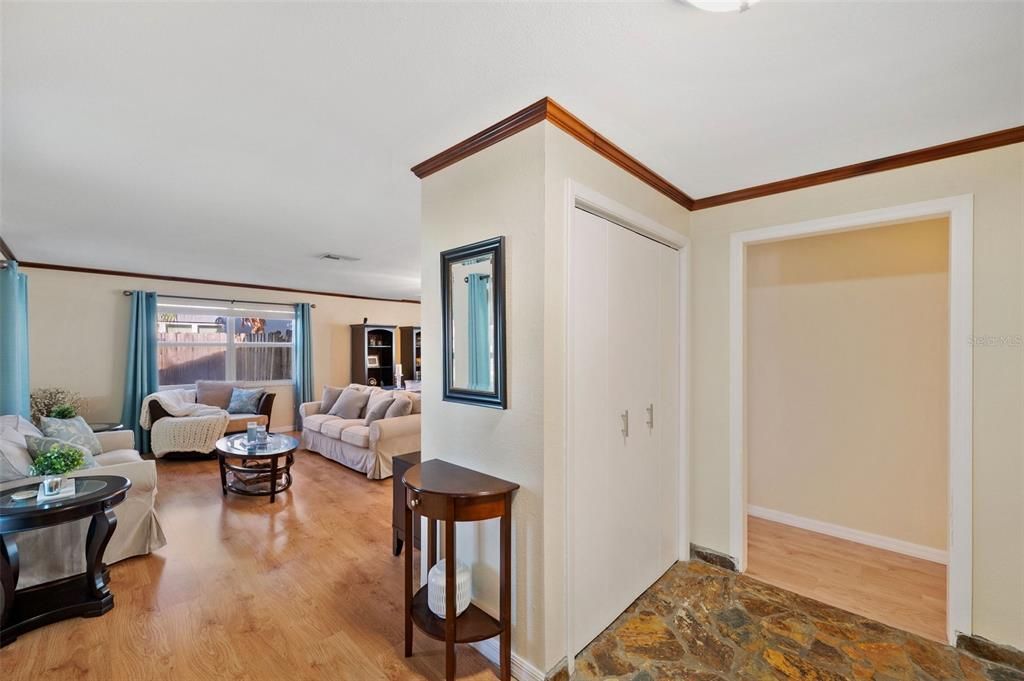 View from front door upon entering: Living Room to the left, Foyer with Coat Closet ahead followed by hall to 3 Bedrooms