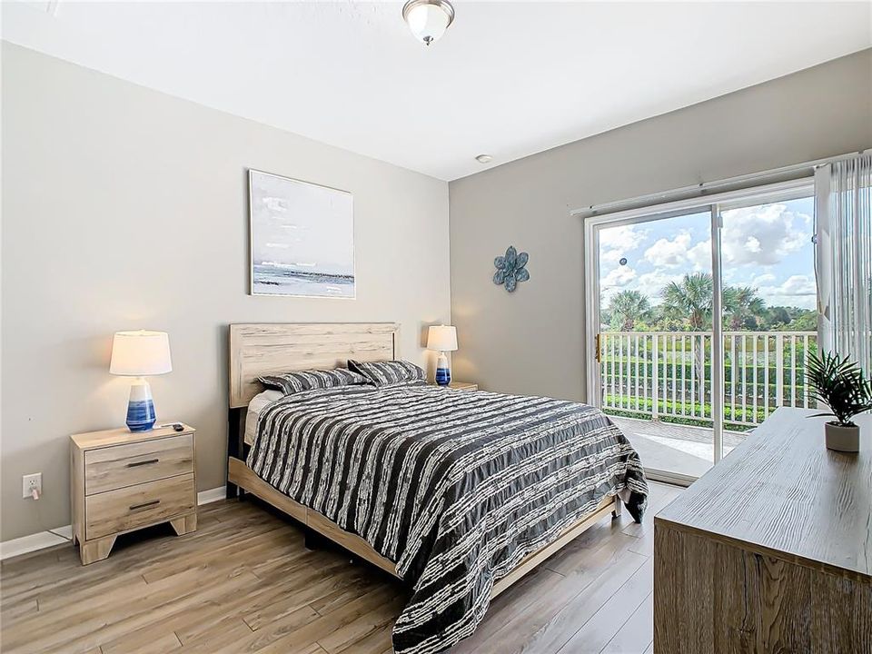 Upstairs primary bedroom with balcony overlooking pool