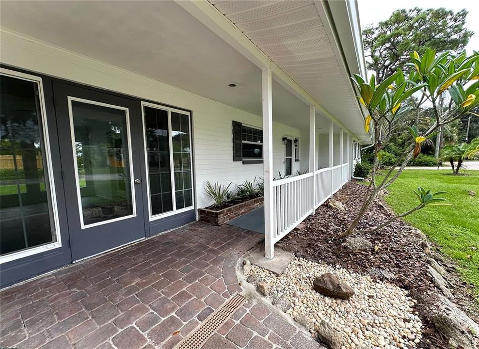 Glass French Door with sidelight windows  opens to the Sunroom