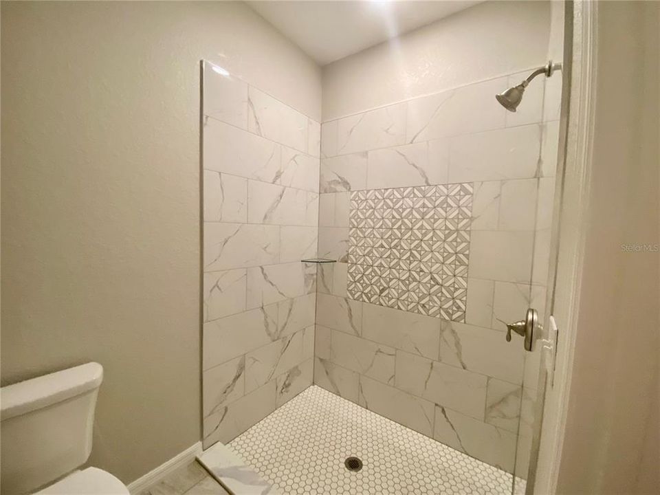 primary bath with tiled walk-in shower. Glass shower door coming real soon!