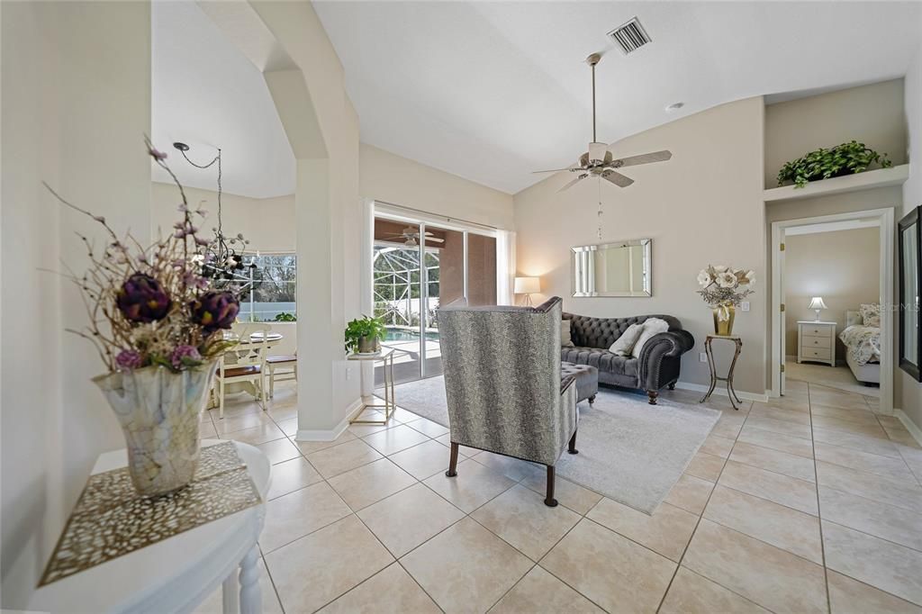 Sitting area. Entrance to primary suite on right. Left is the dinette area and entrance to kitchen. Notice tall ceilings and all tile.