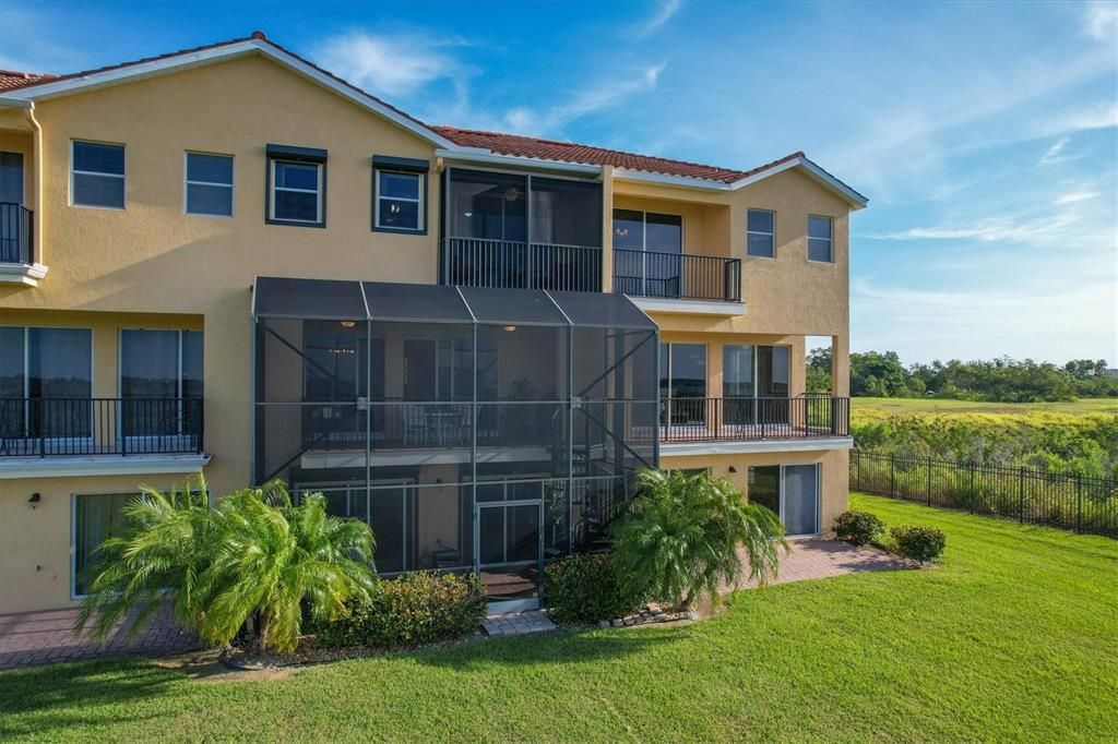 1313 rear w/ 2-story screen-cage, spiral staircase, 3rd story screened balcony, roll-down storm shutters.