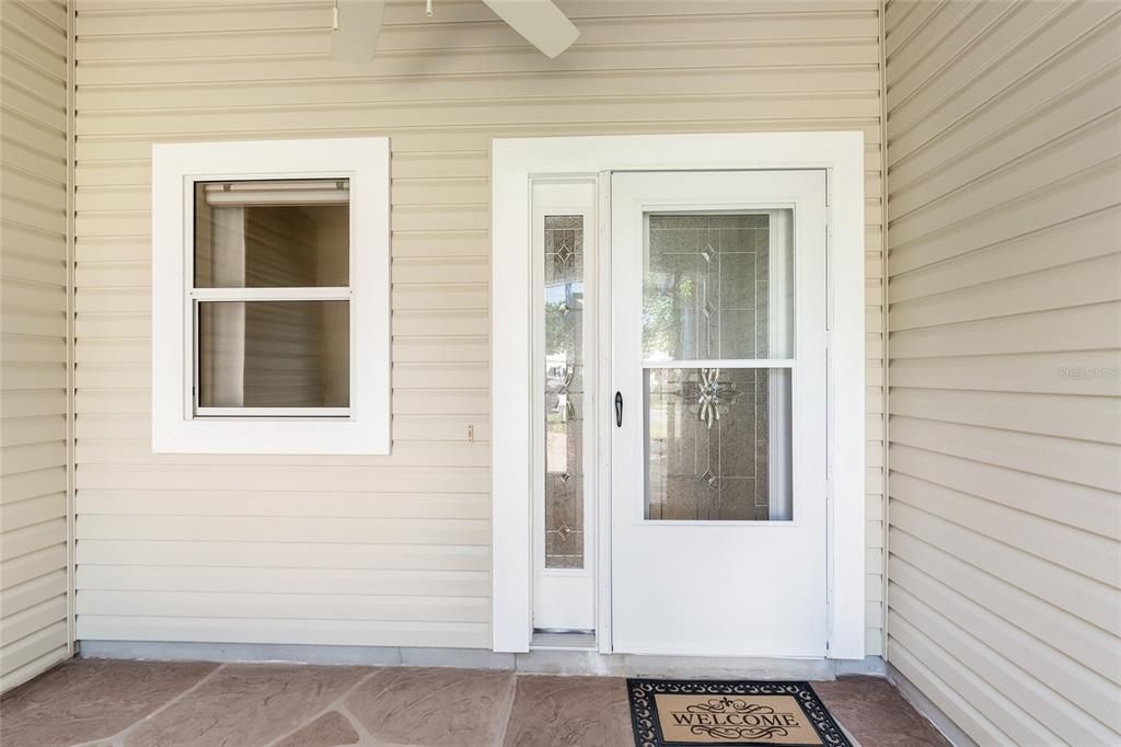 FRONT PORCH view shows storm door & full length leaded glass insert w/ matching sidelight panel