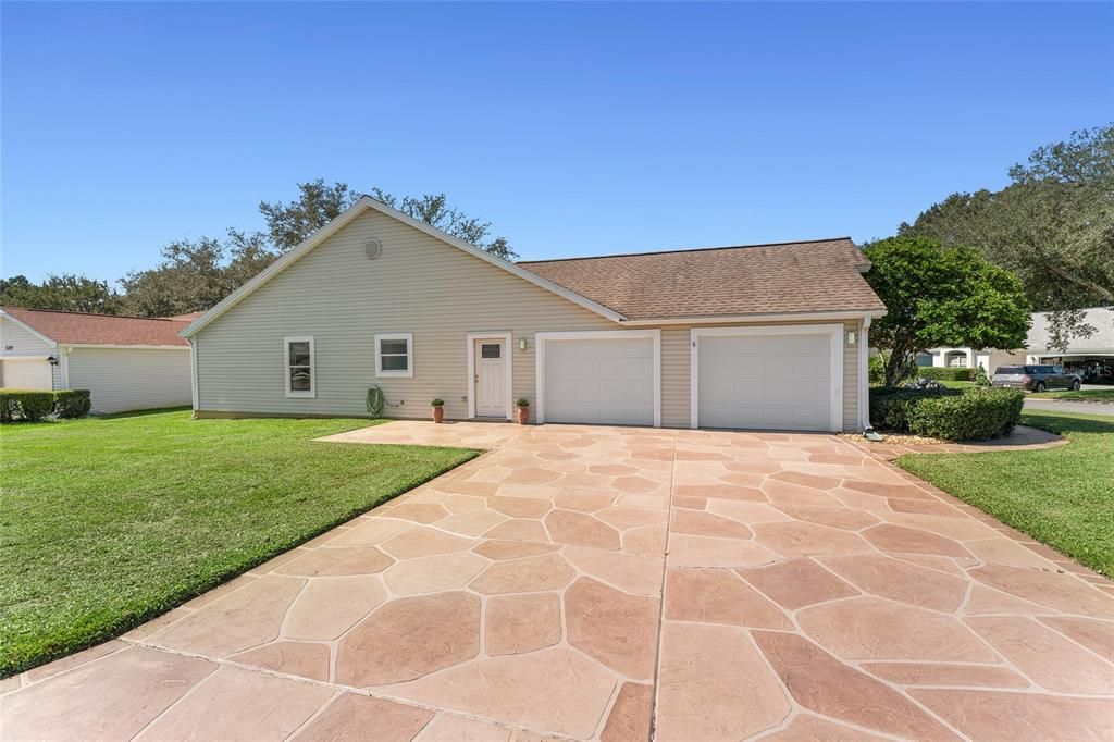 East SIDE EXTERIOR view shows 2 CAR GARAGE & matching imprinted concrete driveway.