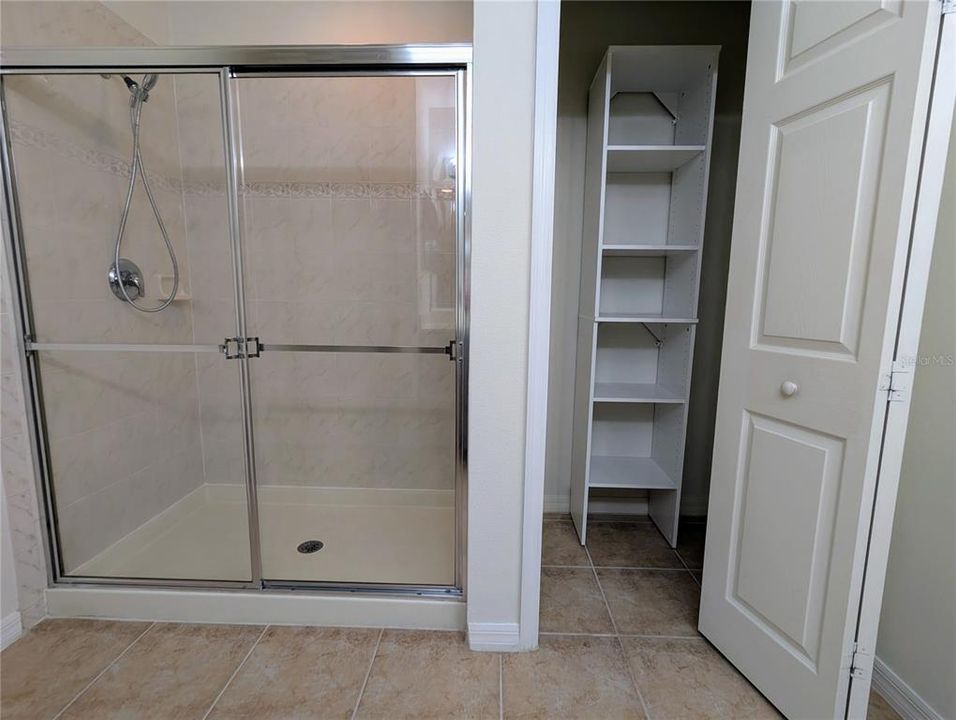 Primary bath features walk-in shower and closet with built-ins