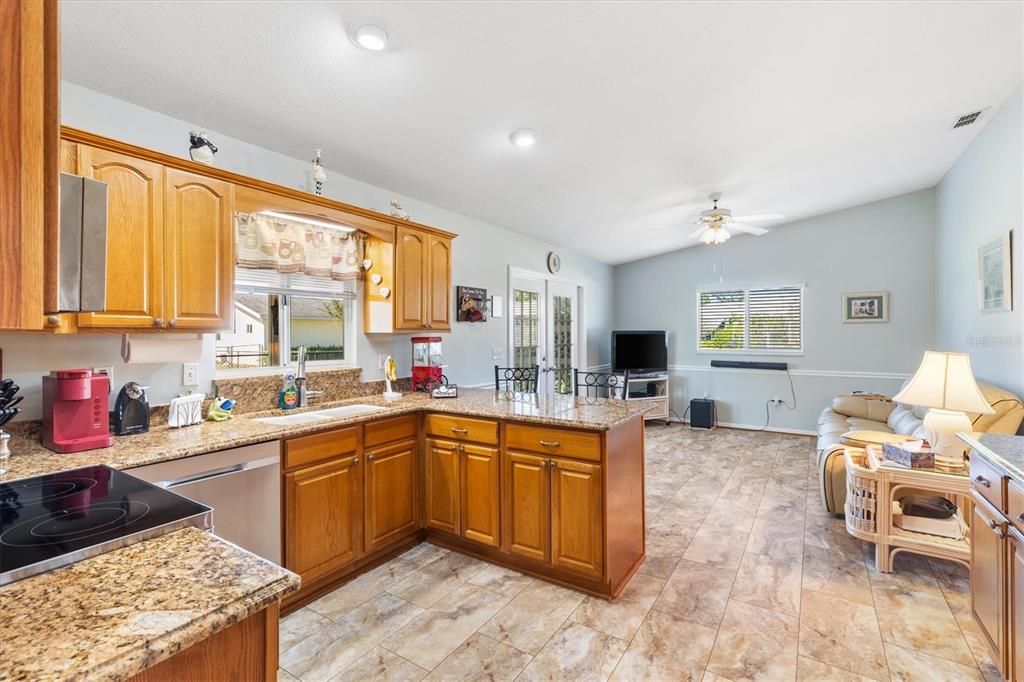 Kitchen has updated cabinets, tile, granite counters, Stainless Steel appliances and room for another living area or dining in kitchen