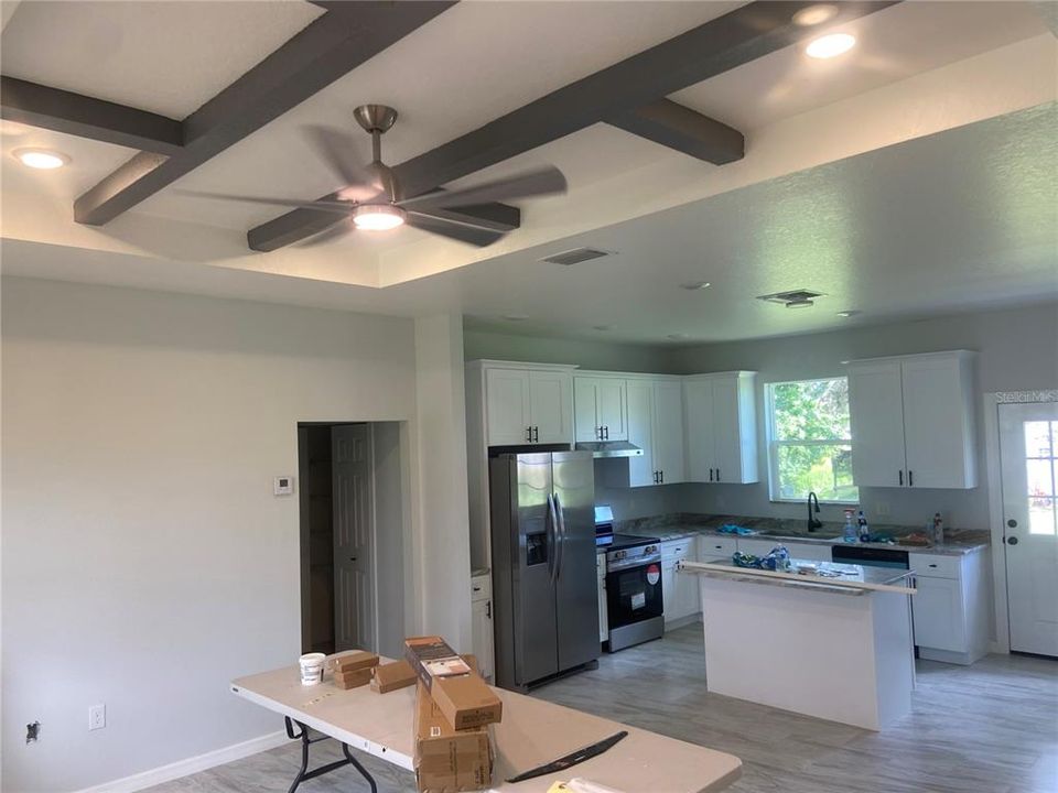 great room with coffered ceiling & recessed lights,