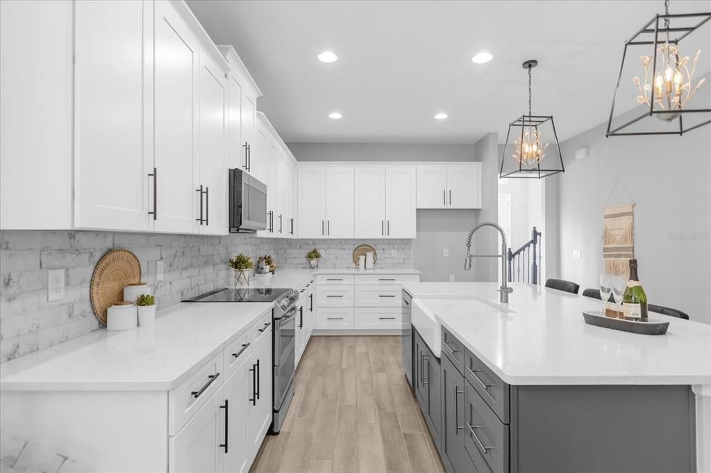 There is a massive ISLAND with breakfast bar seating for casual dining or entertaining, QUARTZ COUNTERS, a CUSTOM TILED BACKSPLASH, farmhouse sink and the WALK-IN PANTRY gives you all the storage you could want and more!