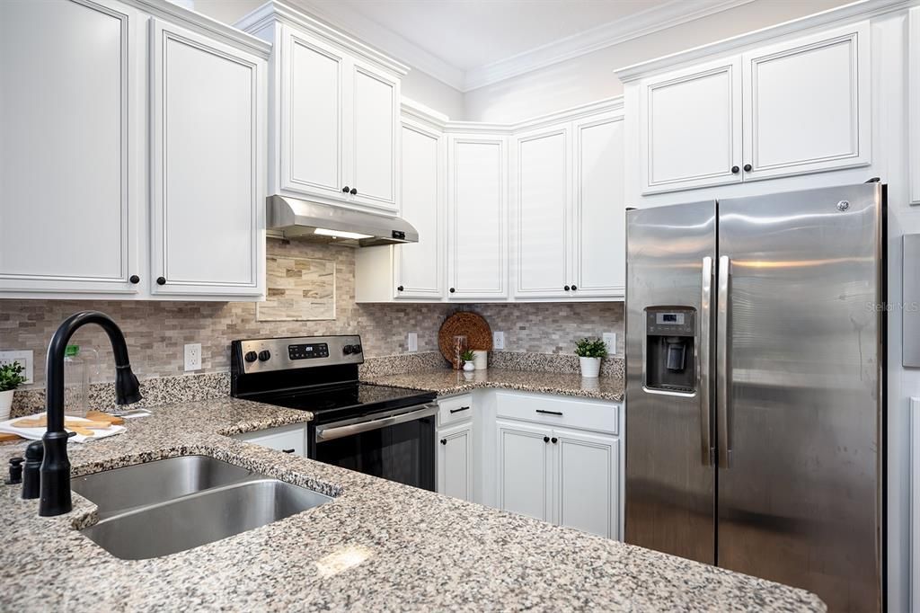 Granite counters, 42" cabinets, tile backsplash, stainless steel appliances in the kitchen