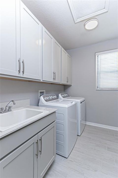 upstairs laundry room with cabinets, sink and counter top - awesome!