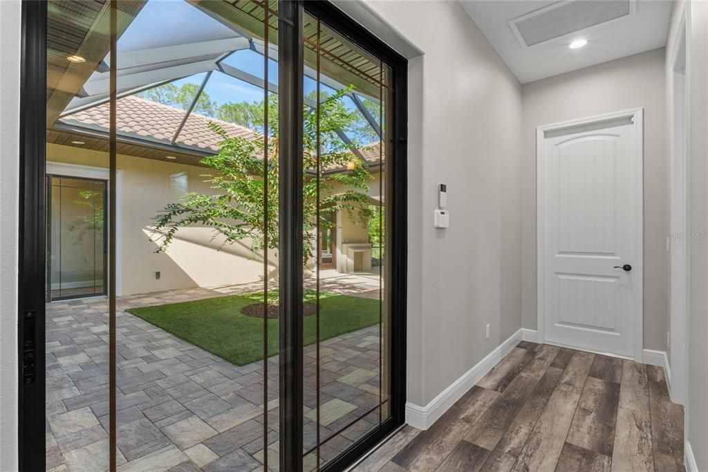 Hallway to laundry room, half bath and gaarge - view out to screened courtyard