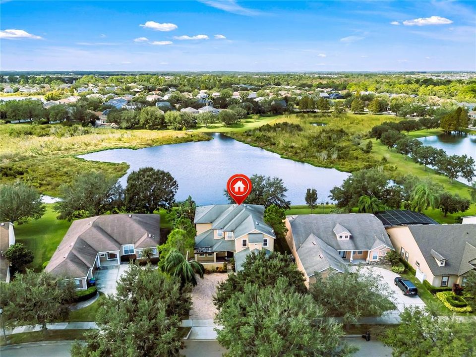 The front of the residence and Cardinal Pond shows the over half-acre of land