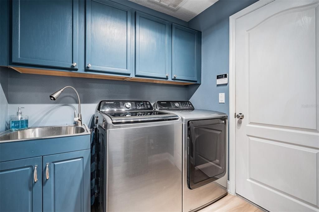 Walk in laundry room featuring a utility sink and built ins